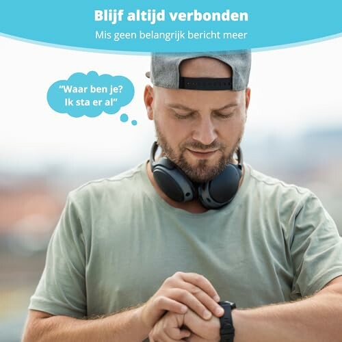 Man kijkt naar smartwatch met koptelefoon om nek