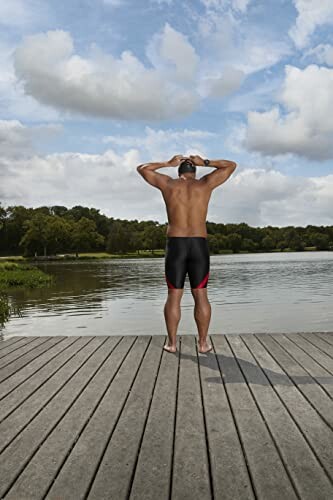 Man staat op steiger bij meer